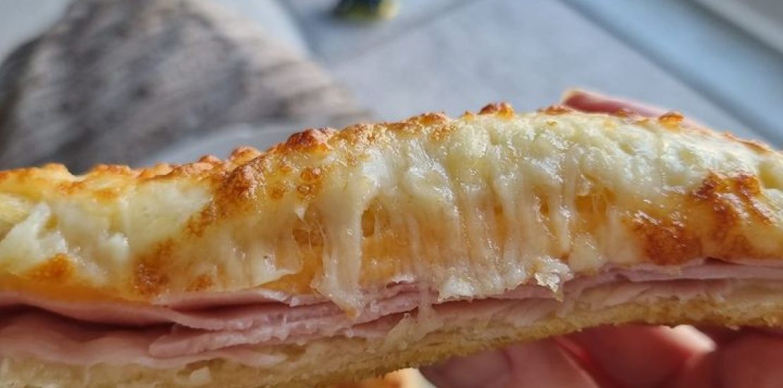 2 pieces of bread, some ham and cheese made into a sandwich.