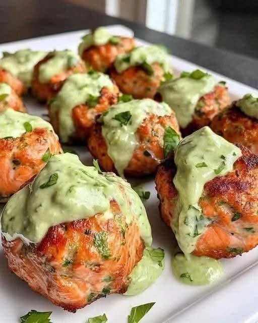 A close-up photo of a healthy Baked Salmon Meatballs showing a moist crumb texture with visible fresh green herbs.
