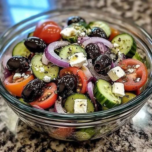 8 Secrets to Make the Best Classic Greek Salad 1 A colorful bowl of Classic Greek Salad with ripe tomato wedges, cucumber slices, red onion, kalamata olives, and a block of feta cheese