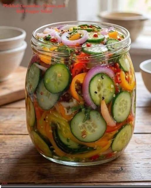 8 Secrets to Make the Best Pickled Cucumber Salad 1 A glass bowl filled with colorful Pickled Cucumber slices, red bell peppers, and red onions in tangy brine