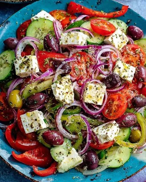 Fresh Authentic Greek Salad with tomatoes, cucumbers, Kalamata olives, and a slab of feta cheese