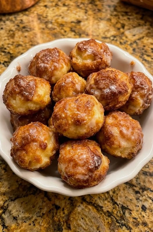 Delicious baked apple fritter bites topped with cinnamon sugar and sweet vanilla glaze on a platter